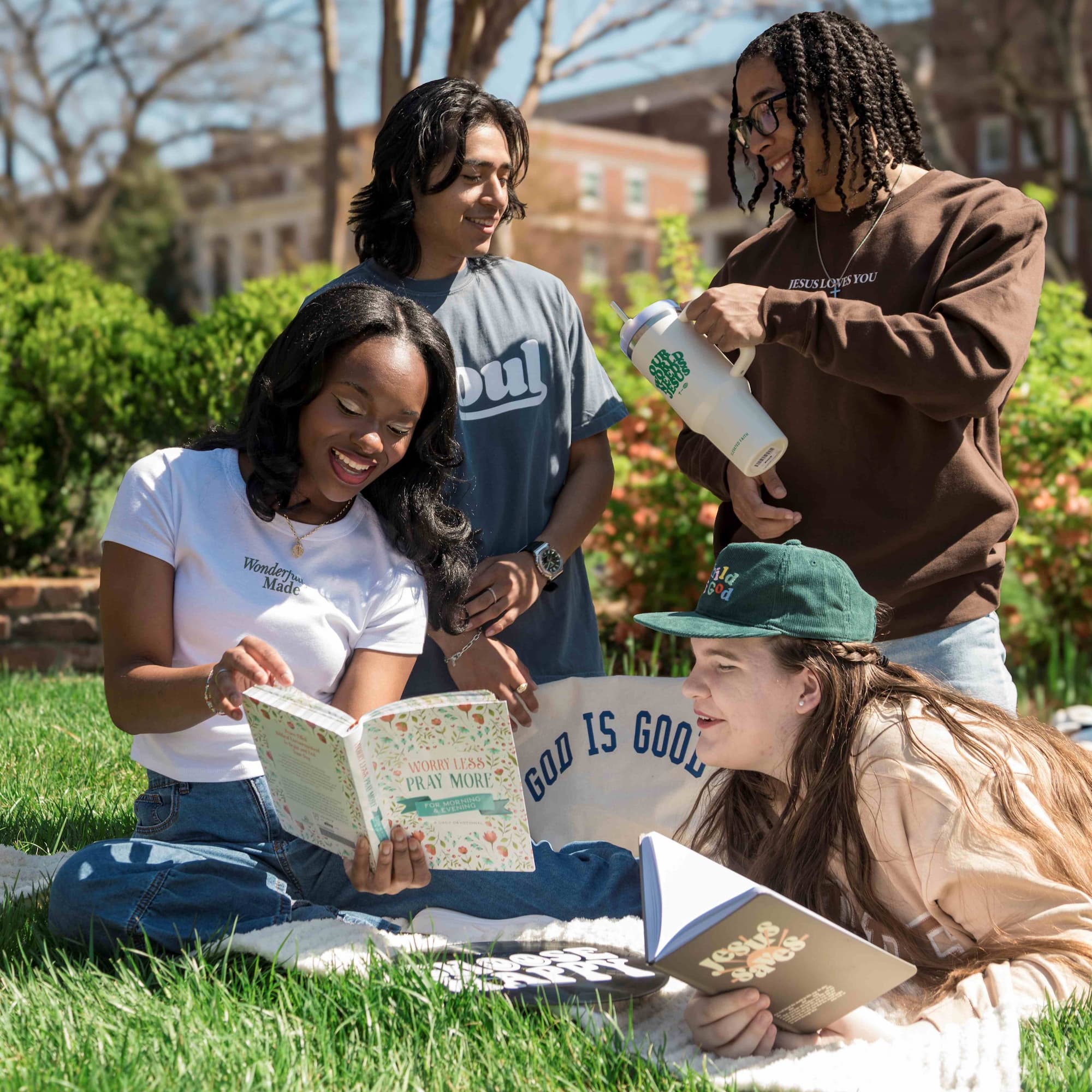 4 Belmont students laying in the grass and reading various books. Click to view Instagram post