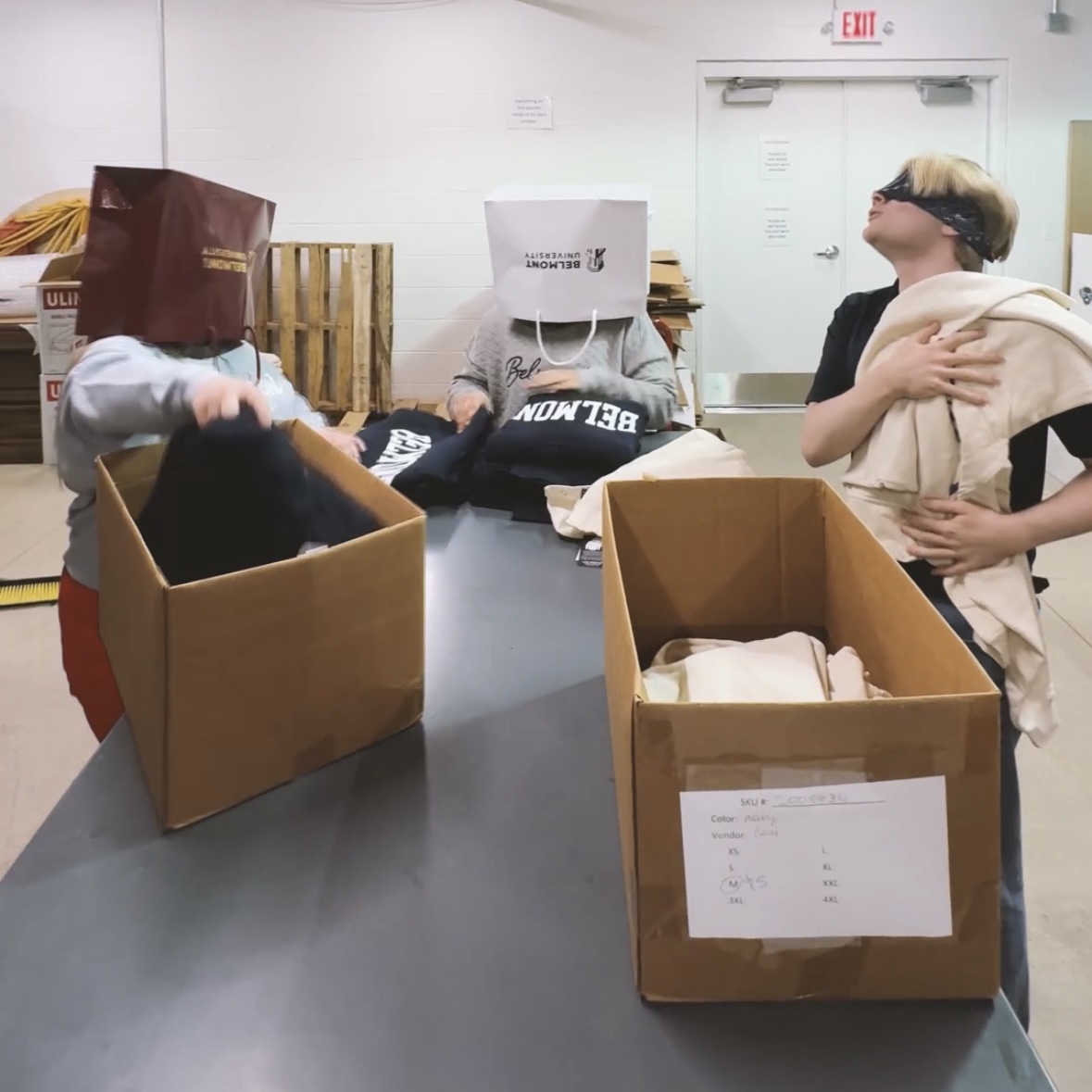 3 people in a warehouse area with 2 wearing shopping bags on their head and the 3rd being blindfolded. Click to view Instagram post