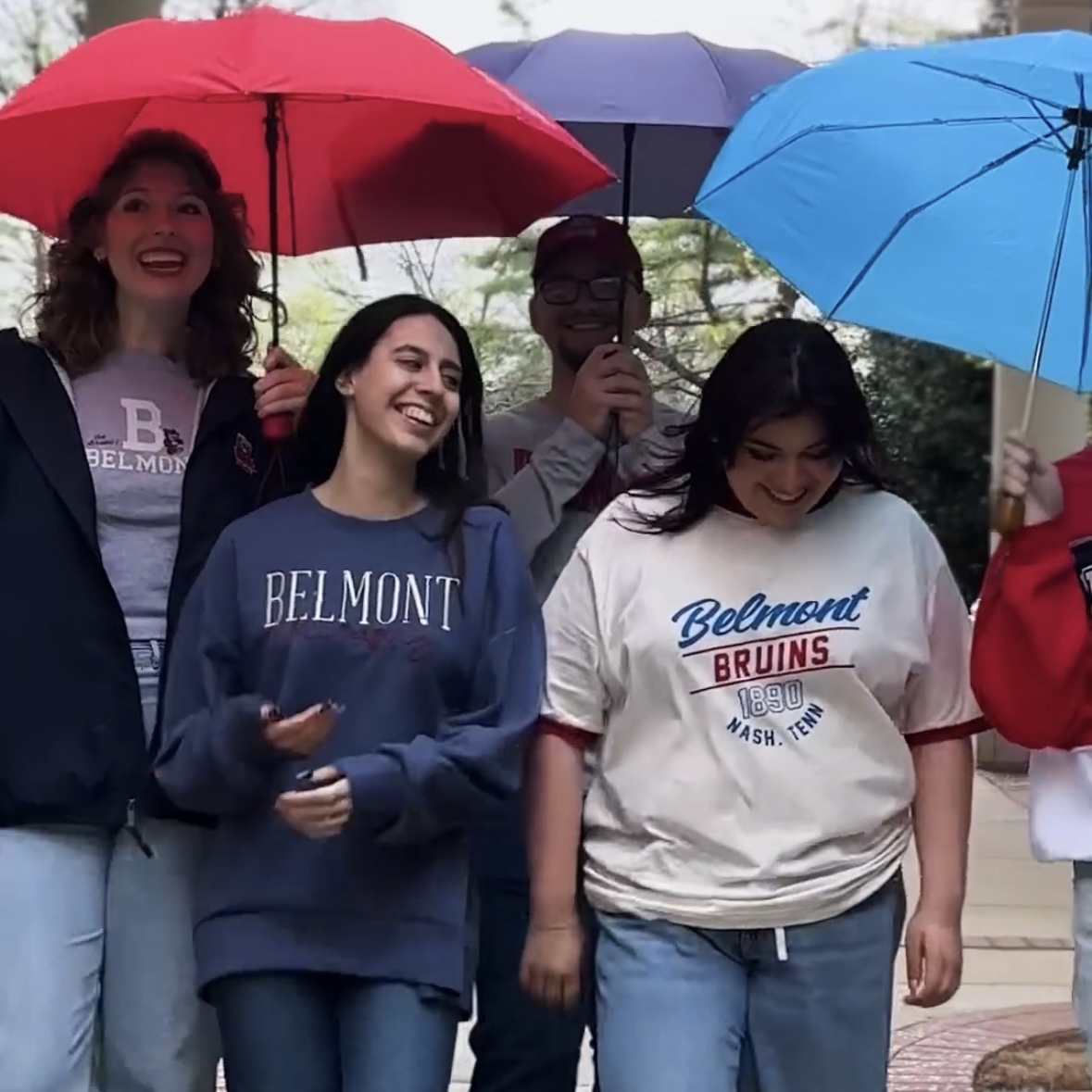 Several people wearing BruinShop clothing and standing under umbrellas. Click to view Instagram post