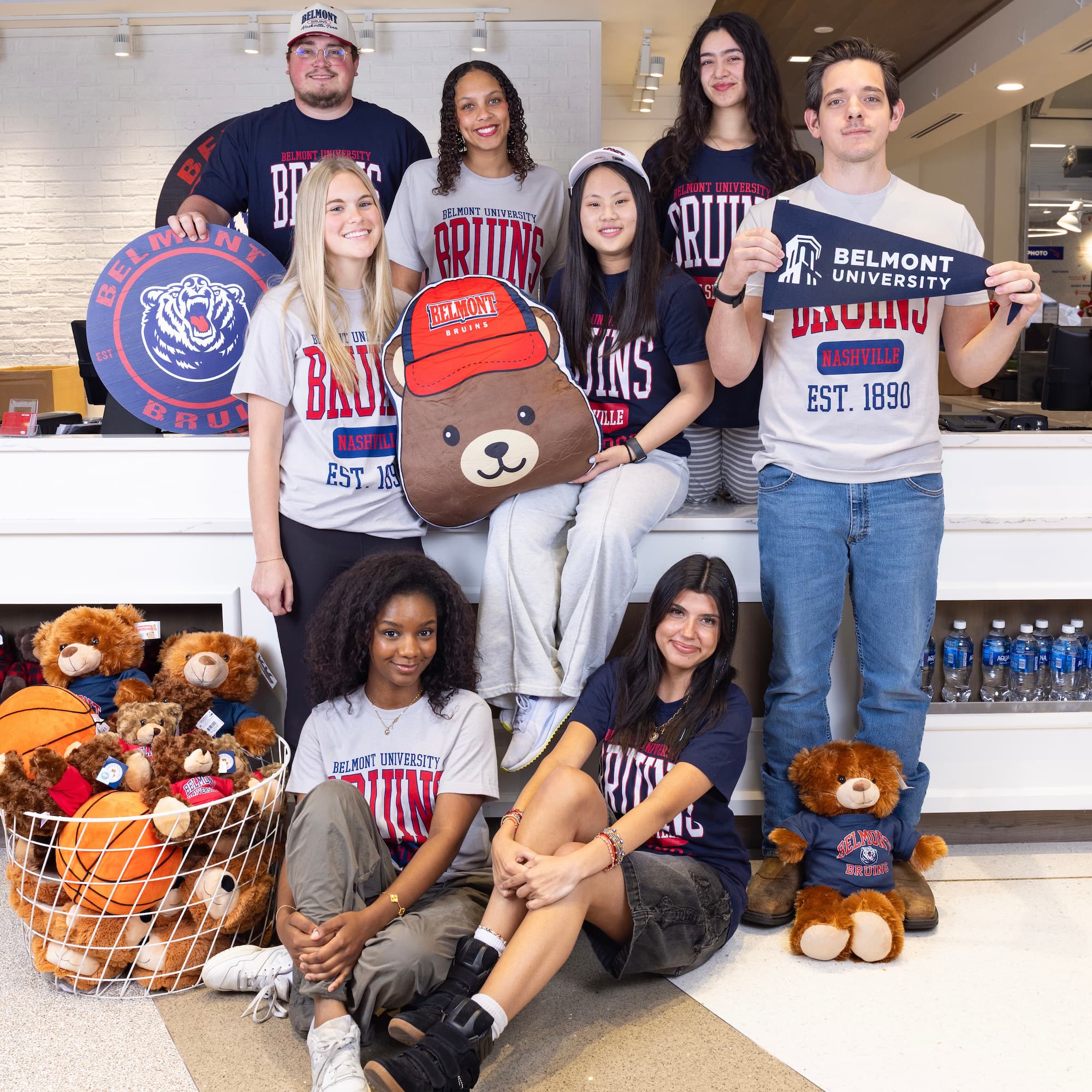Several people posing in the BruinShop on and around the counter. Click here to view Instagram post